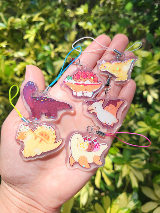 Six handmade phone charms by OsoCuteClub featuring their Mesozoic Bites designs. These cute characters are food-inspired dinosaurs.